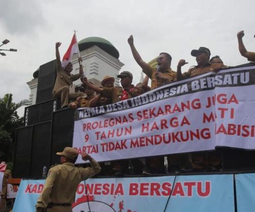 Kades demo di depan gedung DPR sambil memegang spanduk bertuliskan tuntutan jabatan 9 tahun