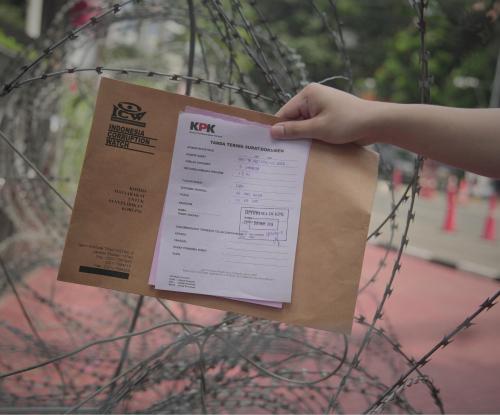 Gambar surat terima pengiriman surat dari KPK yang dipegang di tengah kawat berduri