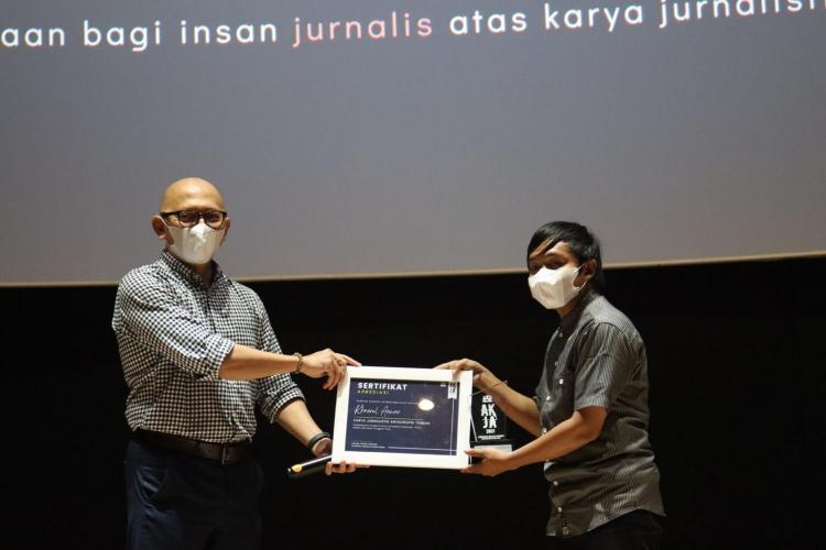 Eric Sasono (Kiri) menyerahkan piagam penghargaan kepada Khaerul Anwar (Kanan) sebagai pemenang karya liputan mendalam/investigasi terbaik dalam AKJA 2021