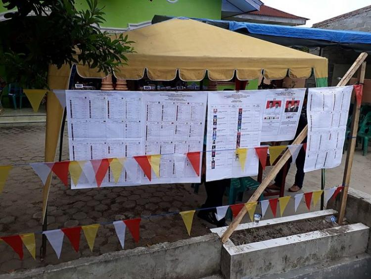 The staggeringly long list of candidates voters were choosing between hangs outside a polling station in North Sumatra. Photo from Wikimedia Commons/ Davidelit.